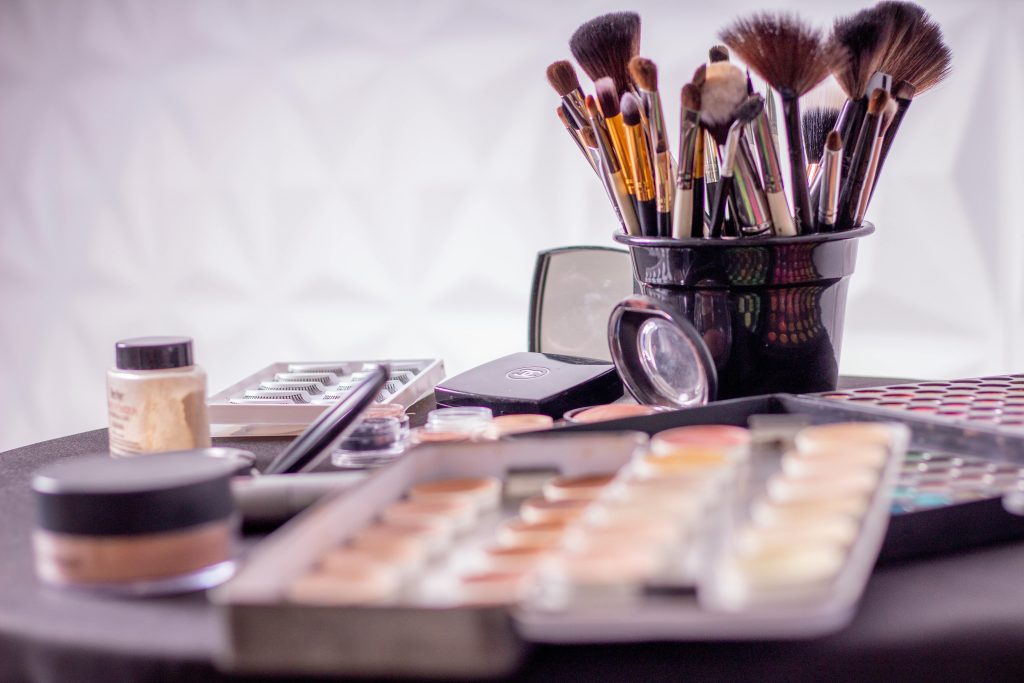 pexels-photo-1115128-1115128 Close-up of a professional makeup brush set and cosmetics on a table for beauty use.